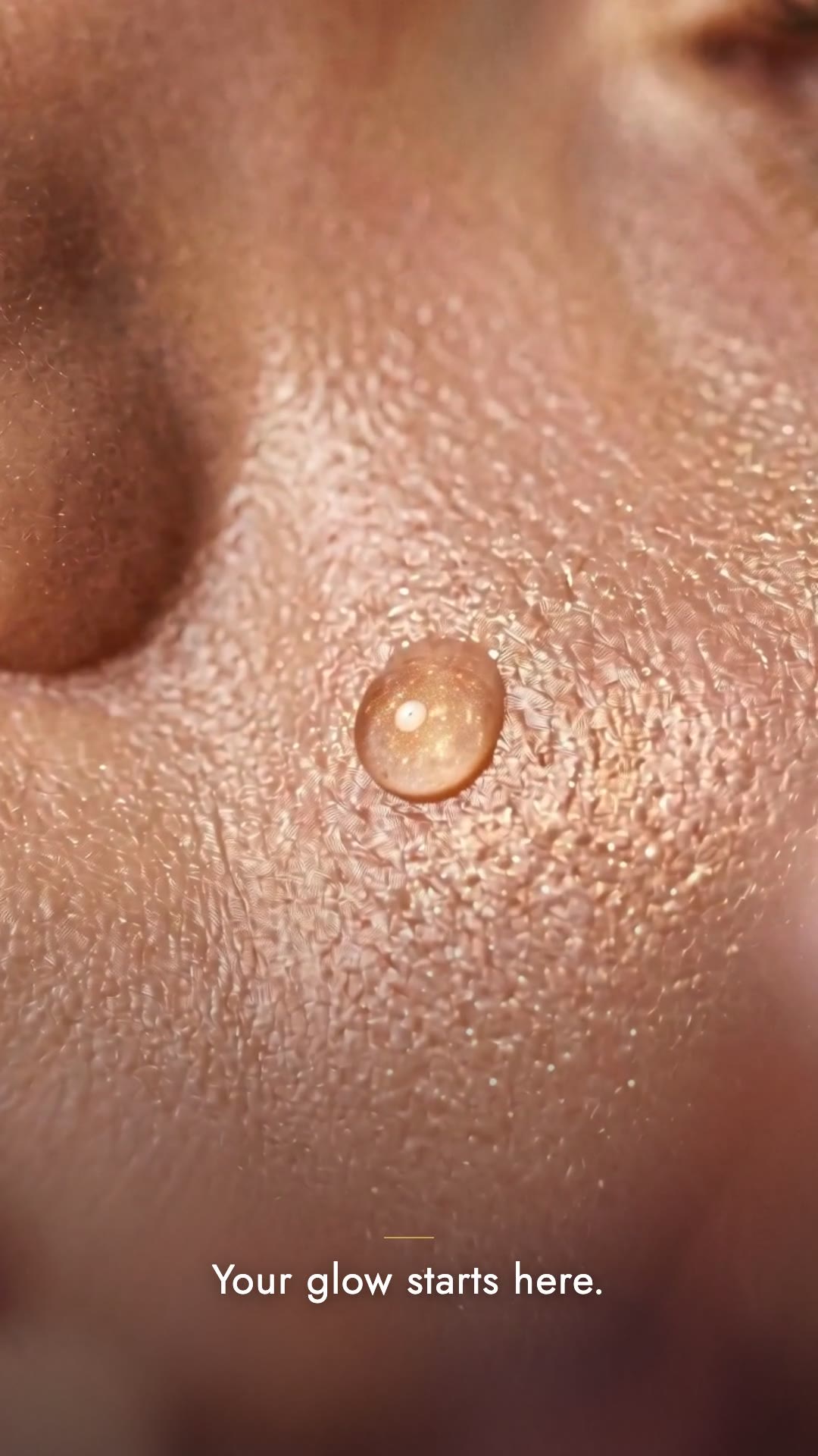Frame from the beauty teaser — glowing skin macro
